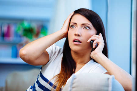 Frightened young woman talking on the phone