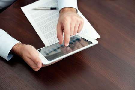 Businessman using digital tablet by the deskの写真素材