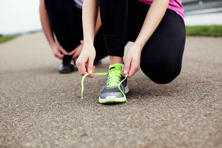 Couple tie shoe before running closeup