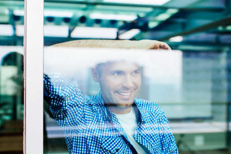Handsome man looking through a big window