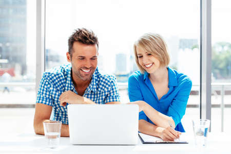 Young couple looking at the laptop display and smilingの写真素材