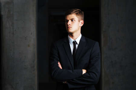 Portrait of young businessman against a concrete wallの写真素材