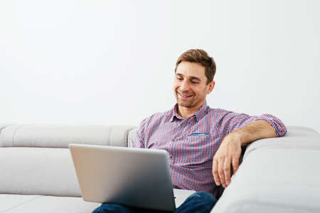 Relaxed man enjoying time with a laptopの写真素材