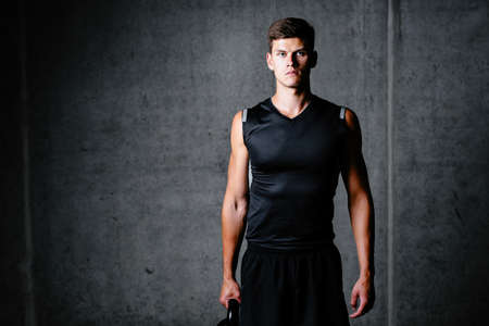 Photo of a strong athlete holding a kettlebellの写真素材