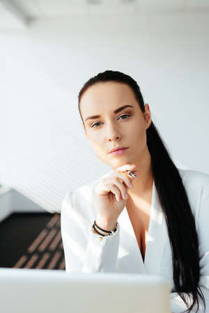 Photo of a attractive female white-collar worker sitting at the laptopの写真素材