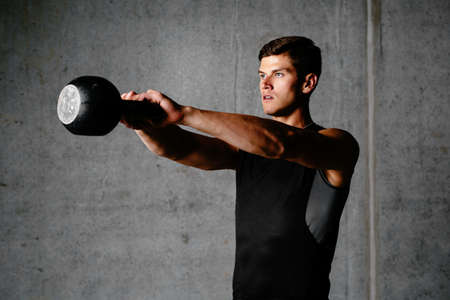 Photo of a sportsman exercising with a weight
