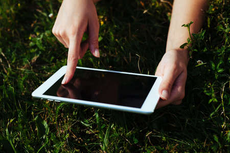 Close-up of female hands holding a digital tablet