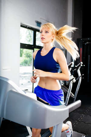 Photo of a female runner on a treadmillの写真素材