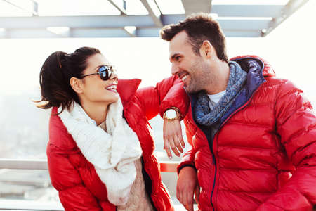 Happy couple enjoying time together at winter time wearing down jacketの写真素材