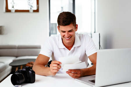 Young photographer editing his imagesの写真素材
