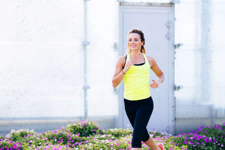 Young happy female athlete running
