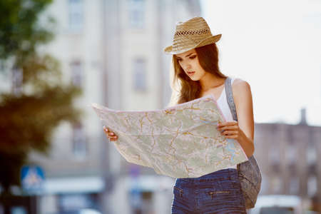 Female tourist reading map during visit at city