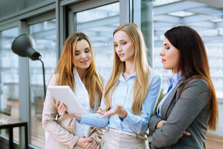 Three young businesswomen discussing ideas at officeの写真素材