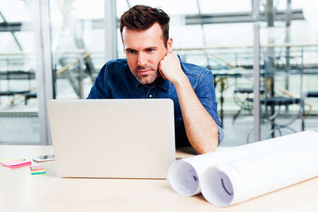 Busy architect looking for inspiration on the webの写真素材