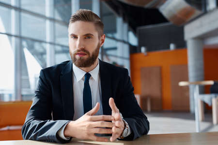 Young businessman with hipster beard looking confident at cameraの写真素材