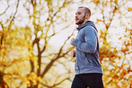 Young athlete running during autumnの写真素材