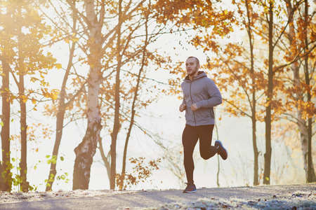 Man running at autumn during sunriseの写真素材