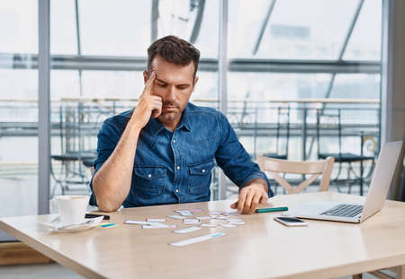 Thoughtful web designer working on website project at officeの写真素材