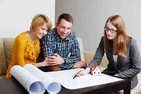 Young couple discussing the blueprints with an architectの写真素材