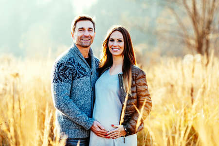 Happy pregnant couple standing outdoorsの写真素材
