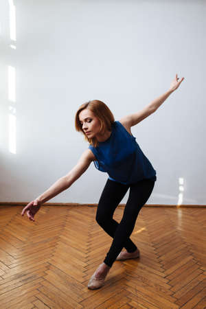 Female ballet dancer stretching her arms in a balanced moveの写真素材
