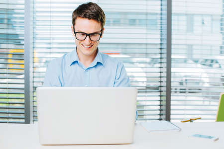 Young man working on laptop in the officeの写真素材