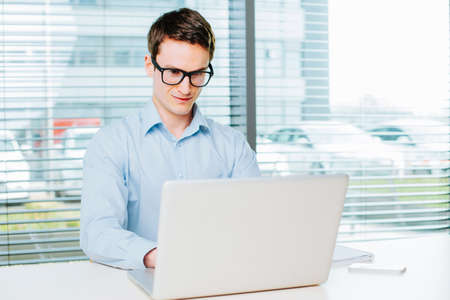 Young businessman working on laptop in the officeの写真素材