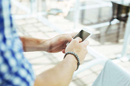 Close-up of a male hands typing a message on a smartphoneの写真素材