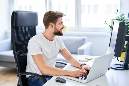 Web designer looking at smartphone while writing notes on whiteboard in modern officeの写真素材