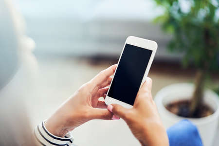 Young woman making phone call to insurance agent while inspecting scratched carの写真素材