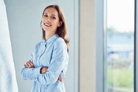 Portrait of young businesswoman in office. Female worker looking at cameraの写真素材
