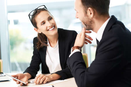 Two colleagues working together with smartphone and business documentsの写真素材