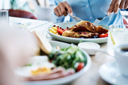 Close up of people having breakfast in restaurantの写真素材