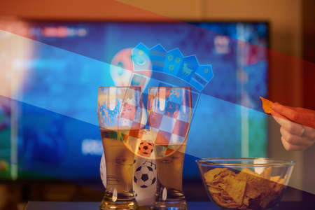 Double exposure of croatian flag and two glasses of beer in front of TV playing footballの写真素材