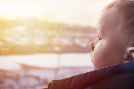 Winter sunset and toddler who looking back with serious faceの写真素材