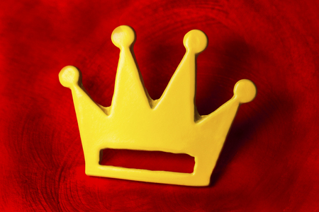 Gold crown on red background. Symbol of winner and luxury lifeの写真素材