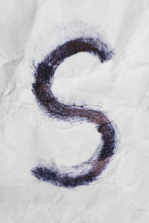 Hand writted black s letter on crumpled paper texture. Depressive symbol in terrible styleの写真素材
