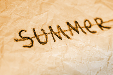 End of summer. Cross out word on crumbled paper texture yellow tonedの写真素材