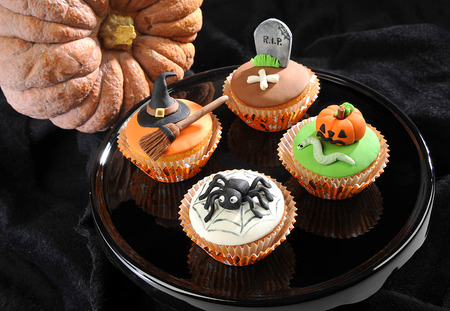 Halloween candy on a black tray with a pumpkin nearの写真素材