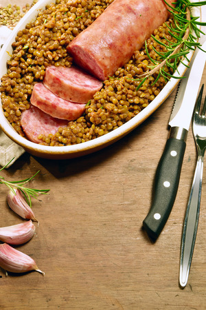 Cotechino with lentils with rosemary served on a plate with some ingredientsの写真素材