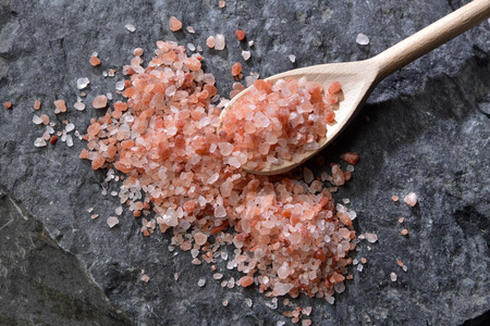 Himalayan pink salt crystals and chopped on to a dark rockの写真素材