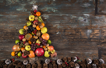 Christmas tree with autumn fruit, pine cones and bright starの写真素材