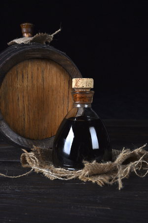 Balsamic vinegar of Modena on a jute canvas and with barrel behindの写真素材