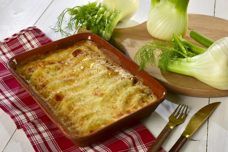 Fennel au gratin baked with bÃ©chamel sauce inside a terracotta dishの写真素材