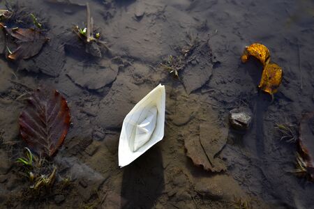 Paper boat floating on a puddleの写真素材