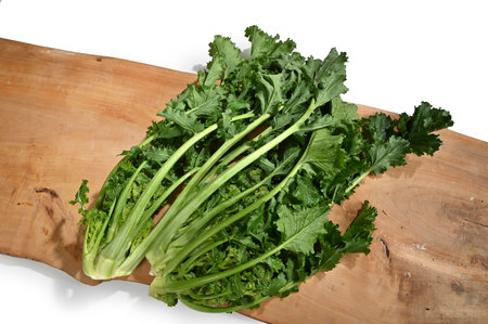 Fresh turnip tops on a wooden table with white backgroundの写真素材