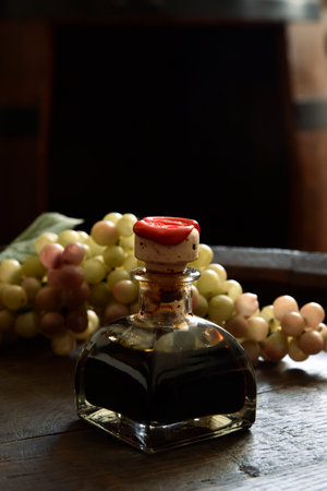 Traditional balsamic vinegar of Modena in a small bottle on a wooden barrelの写真素材