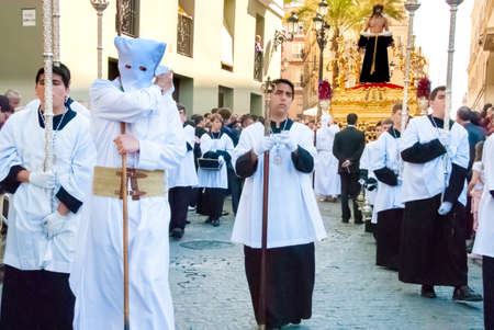 Easter procession during Holy Week in Spain. In front: penitents, in the back: Jesus figure on the float. Cadiz, Andalucia, Spainのeditorial素材