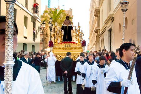 Easter procession during Holy Week in Spain. In front: penitents, in the back: Jesus figure on the float. Cadiz, Andalucia, Spainのeditorial素材
