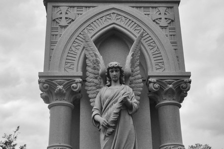 Statue of an Angel Looking Down in a Cemeteryのeditorial素材